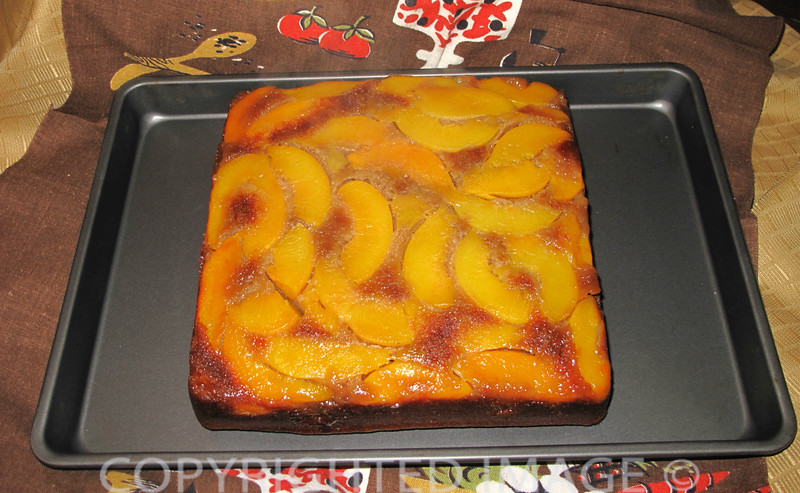 Gingerbread Peach Upside Down Cake right out of the oven and cooling on a cookie sheet