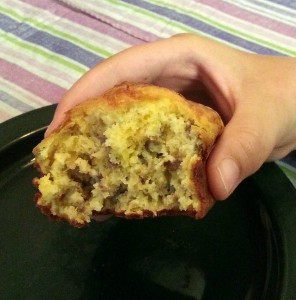 Taking a giant bite out of a sausage and cheddar muffin.