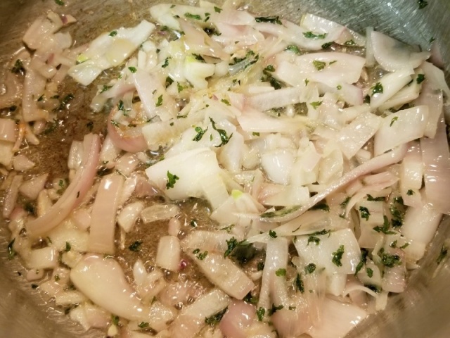 Sliced shallots cooking in olive oil and butter.