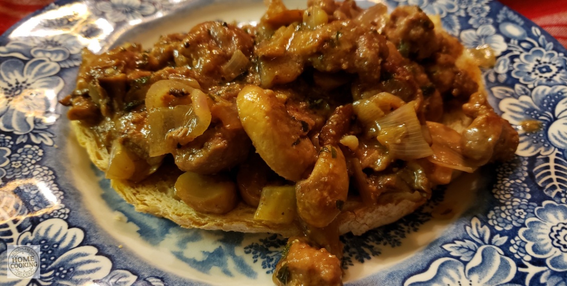 plate of sauteed kidneys with mushrooms and shallots on a slice of toasted country bread. rognons-de-veau-aux-champignons