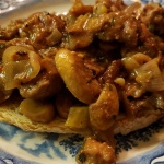 plate of sauteed kidneys with mushrooms and shallots on a slice of toasted country bread. rognons-de-veau-aux-champignons